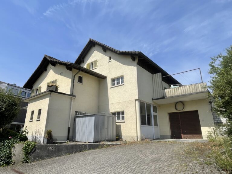 Gebäude der Dorf-Chäsi, alte Käsi, Rickenbach mit heller Fassade, grünen Fensterläden und Balkon im Obergeschoss.